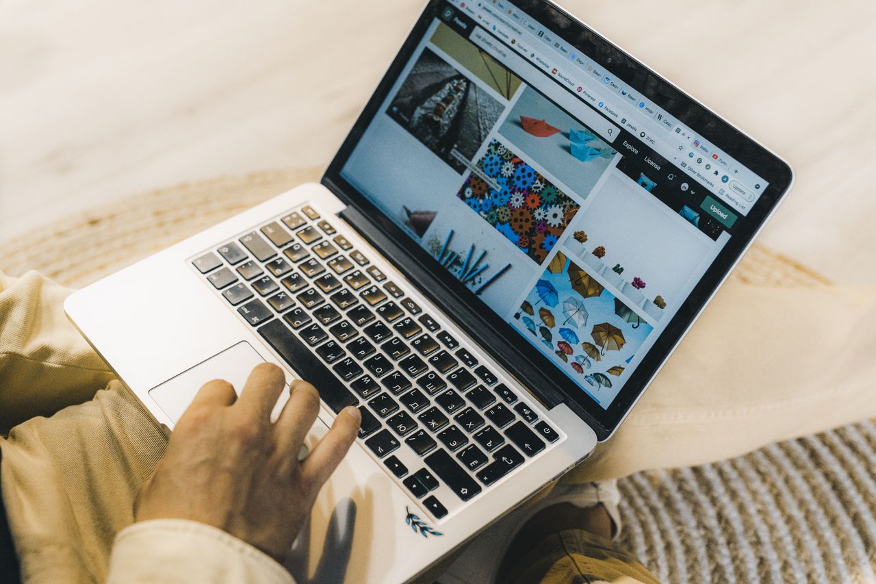 gallery-02 Une personne utilisant un ordinateur portable pour consulter des sites de photos de stock. Travail en freelance dans un cadre chaleureux.
